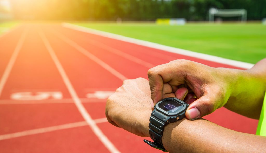 Athlete checking his watch on running track